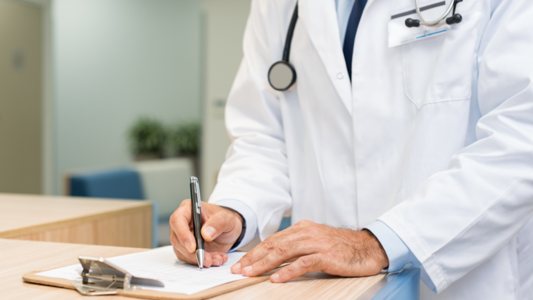 Médico escrevendo em prancheta
