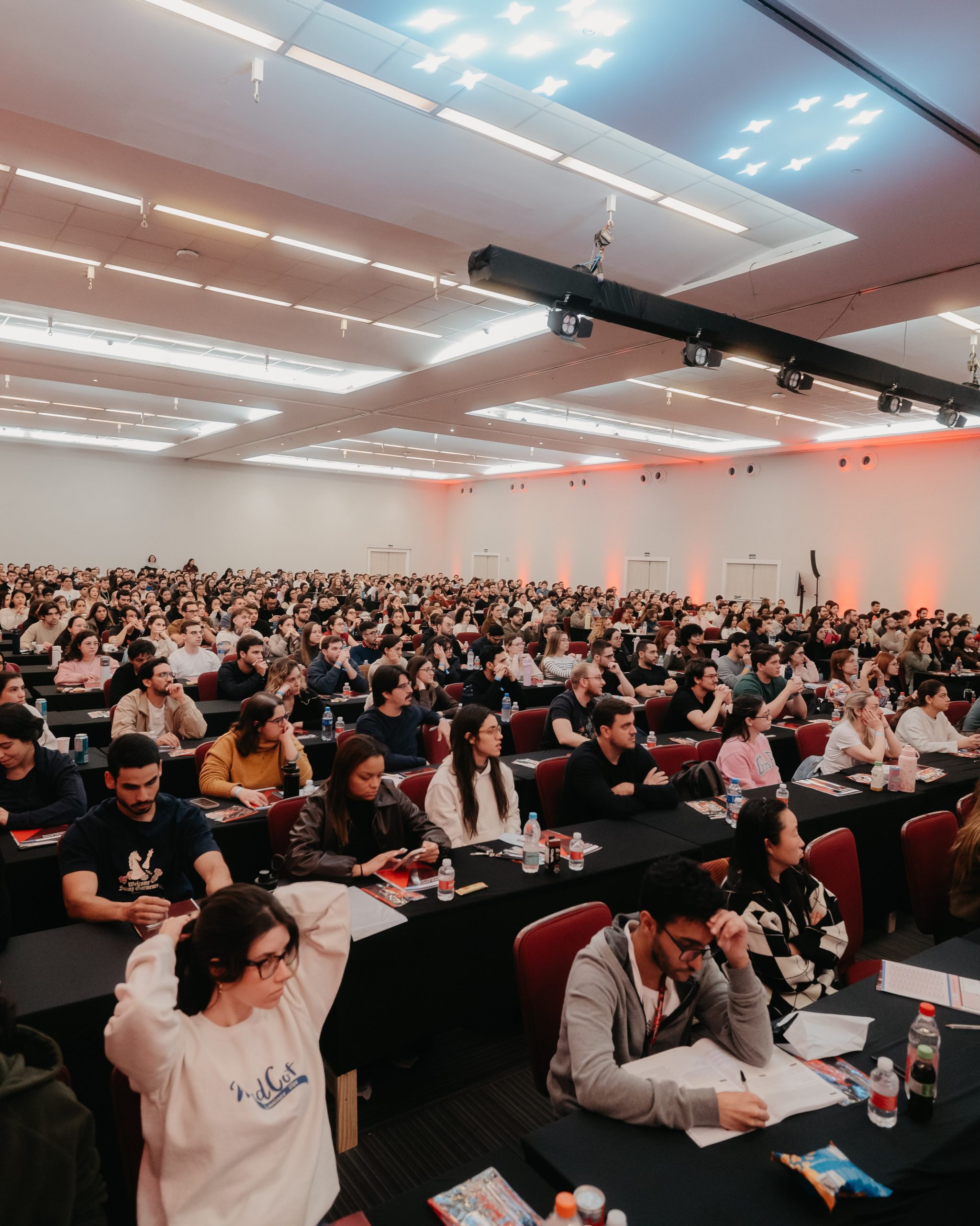 Sala cheia de alunos sentados em carteiras prontos para realizar um simulado.